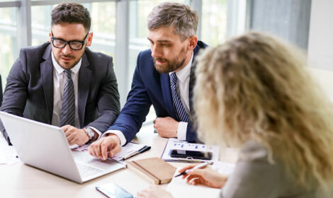 A business team conversing in front of a laptop